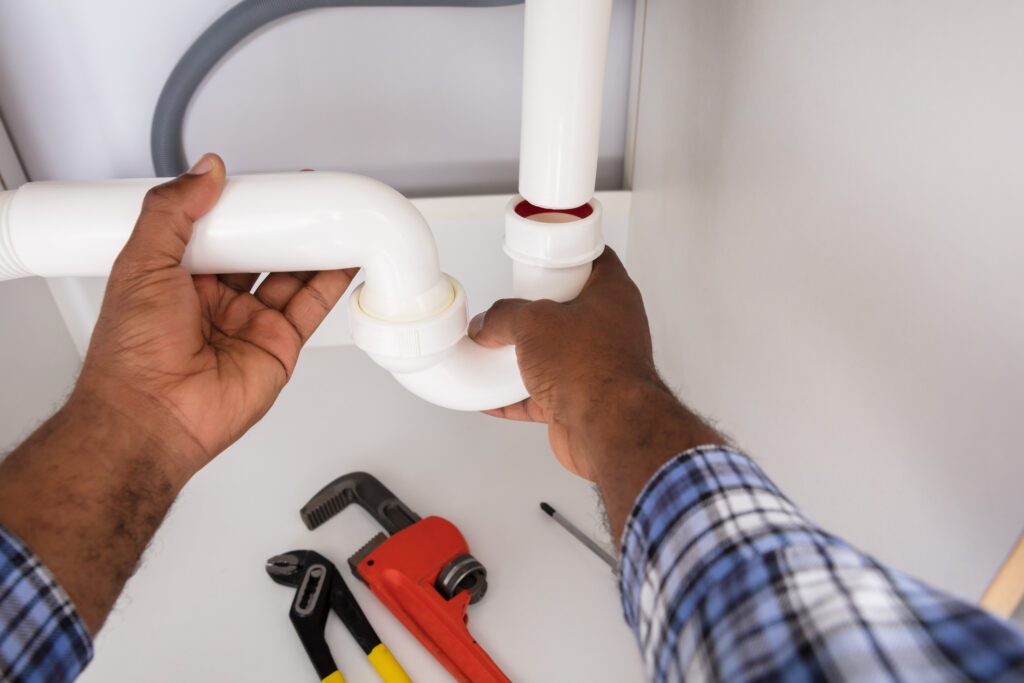 Close-up Of Plumber Fitting Sink Pipe In At a Home
